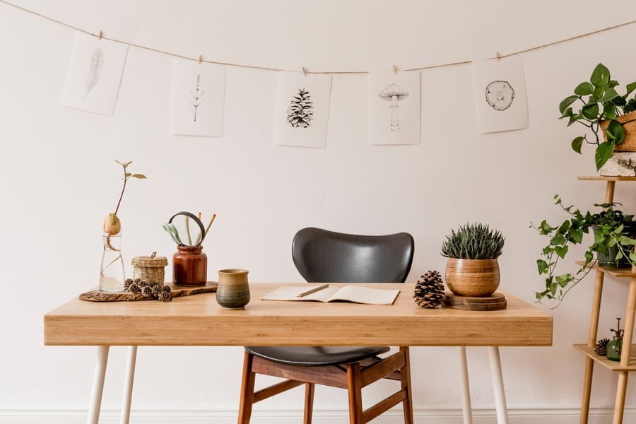 Stylish and scandinavian interior of home office with mock up poster frame. Botany and forest concept of home decor.